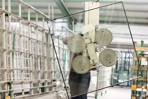 Industrielle Glasproduktion mit moderner Maschine zur Bearbeitung großer Glasscheiben.